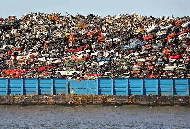 Scrap metal barge loaded with crushed cars for recycling.