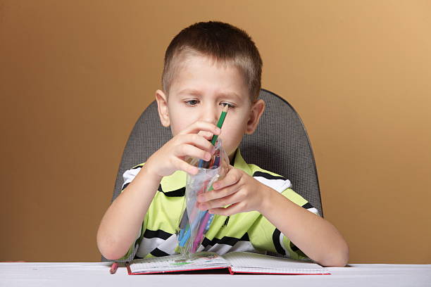 istock Young cute boy draws with color pencils 475026391