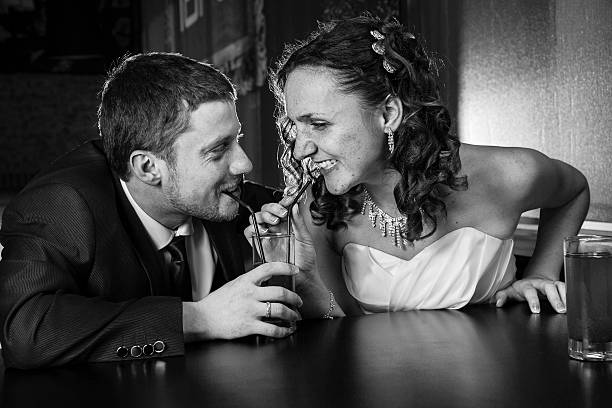 istock Couple in the cafe drinks from the same glass 475026826