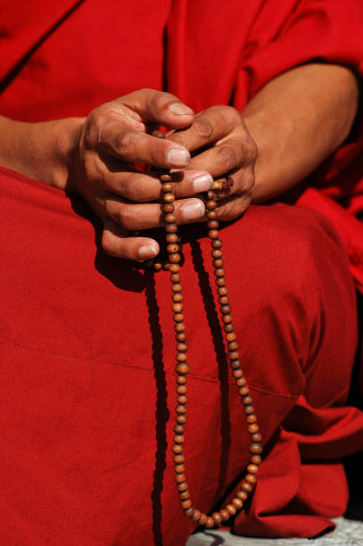 Hands of Asian senior woman holding rosary on bible book in black and white. A spiritual grandmother praying rosary closeup, The Catholic symbol.  Believe in God and pray rosary concept.