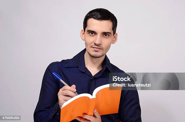 Foto de Estudante Segurando Um Livro Smiling Professor Escrevendo No Notebook e mais fotos de stock de Adulto