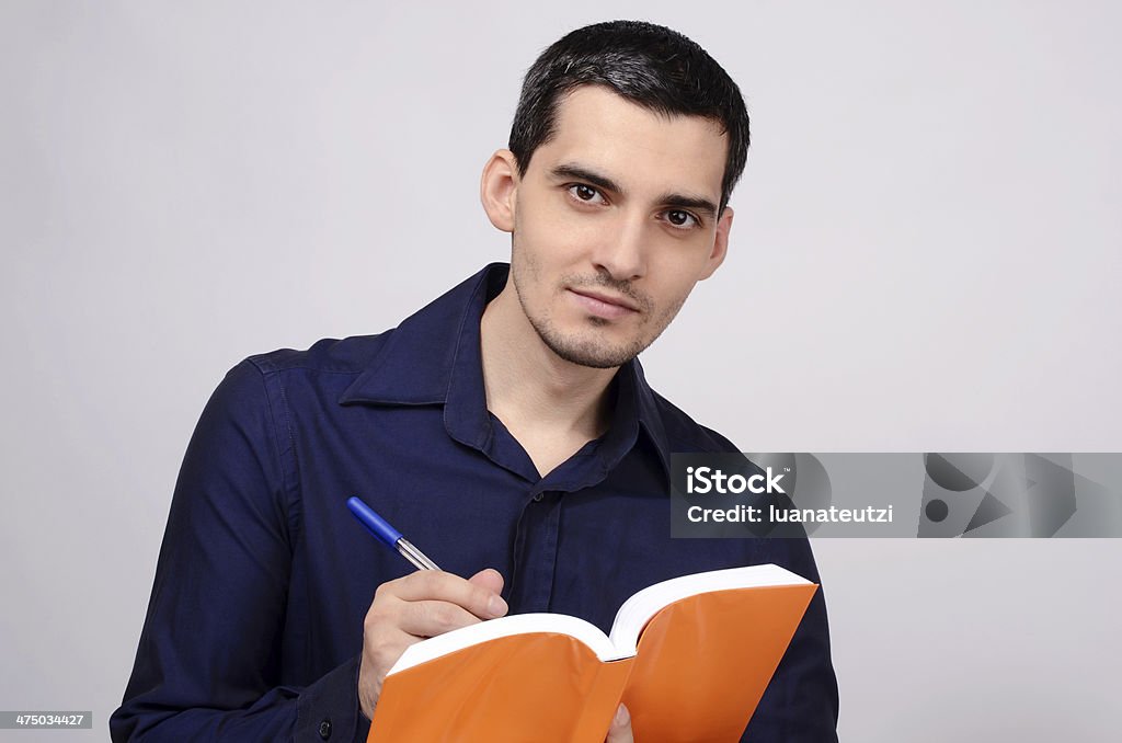 Estudante segurando um livro smiling. professor escrevendo no notebook. - Royalty-free Adulto Foto de stock