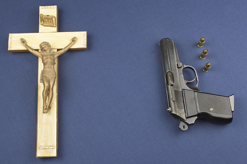 wooden crucifix with the lettering INRI and gun