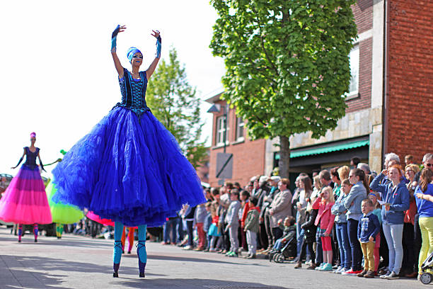 bailarines sobre pilares en desfile del día de mayo en genk bélgica - stilts fotografías e imágenes de stock