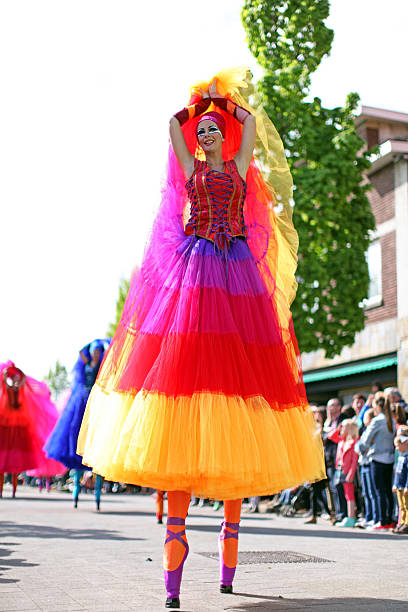 Genk, Belgium - May 1, 2015: Stilt dancer in a colorful dress and ballerina shoes is dancing on the streers of Genk in Belgium during the annual May Day parade. 2015 is the 60th edition of this May Day tradition in Genk, with international street theatre, puppetry, marching bands, etc.