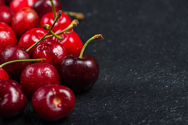 istock Fresh ripe organic cherries on black border  background 475037574