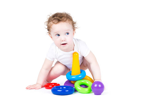 istock Funny baby playing with a colorful plastic pyramid 475041215