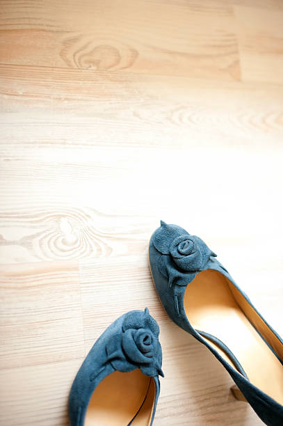 Blue suede leather women shoes Detail of blue suede leather women shoes isolated on white wooden floor. A lot of copy space. Vertical color image. womens blue suede shoes stock pictures, royalty-free photos & images