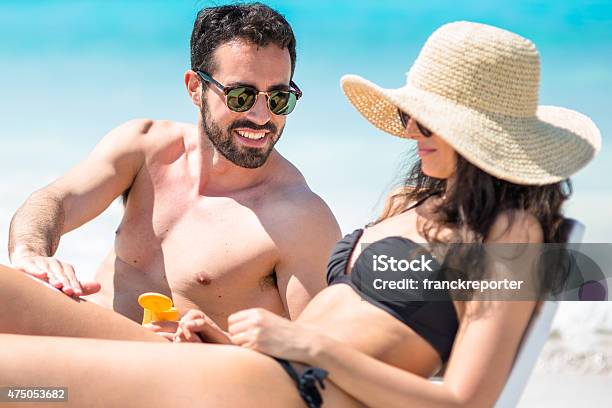 Happiness Couple At The Seaside Relaxing Stock Photo - Download Image Now - Beach, Couple - Relationship, Moisturizer