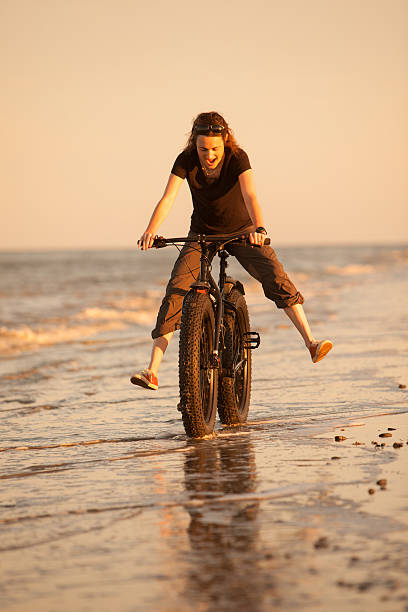Splashing around on a bike at the beach stock photo