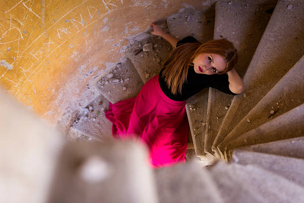 Thoughtful cuban woman standing on steps against wall