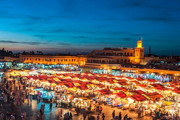 Evening Djemaa El Fna Square with Koutoubia Mosque, Marrakech, Morocco Famous Djemaa El Fna Square in early evening light, Marrakech, Morocco with the Koutoubia Mosque, Northern Africa.Nikon D3x market square stock pictures, royalty-free photos & images