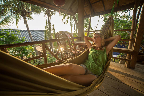 istock Beautiful girl relaxing on hammock at sunset 475058204