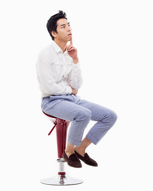 Young Asian man thinking on the chair isolated on white backgroung.