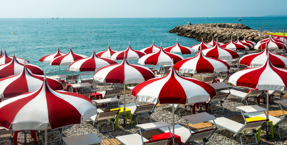 Cagnes-sur-Mer (Alpes-Maritimes, Provence-Alpes-Cote d'Azur, France), red and white umbrellas on the beach