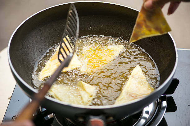 istock Dough sheet deep frying in very hot oil. 475068970