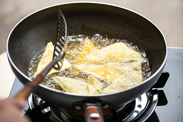 istock Dough sheet deep frying in very hot oil. 475068990