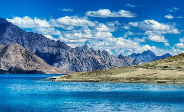 Mountains and Pangong tso (Lake). It is huge lake in Ladakh, altitude 4,350 m (14,270 ft). It is 134 km (83 mi) long and extends from India to Tibet. Leh, Ladakh, Jammu and Kashmir, India