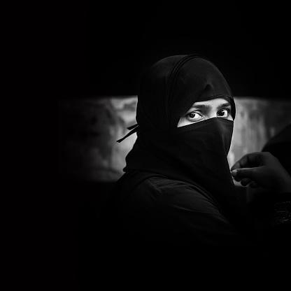 Jaipur, India - March 8, 2015: Indian muslim woman in jaipur city wearing a niqab, this garment is a veil that covers the head and face but not the eyes, is used together with another piece of garment call abaya that covers from the head to the feet.