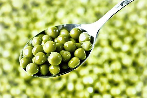 green peas on the spoon stock photo