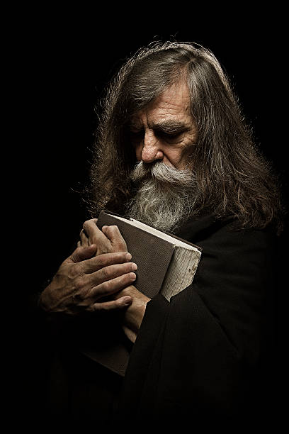 istock Senior Prayer, Old Man Praying with Hands on Bible Book 475074824