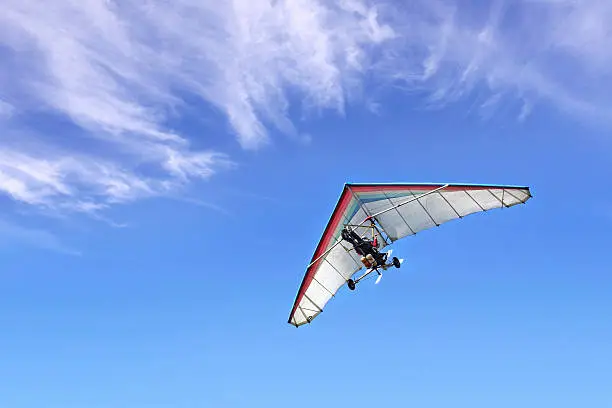 The motorized hang glider in the blue sky