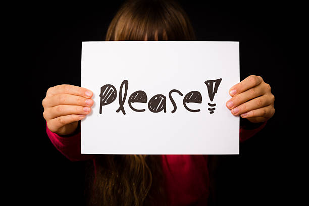 istock Child holding Please sign 475076386