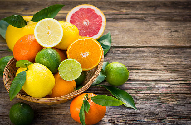 Citrus fruits in the basket on the rustic table stock photo