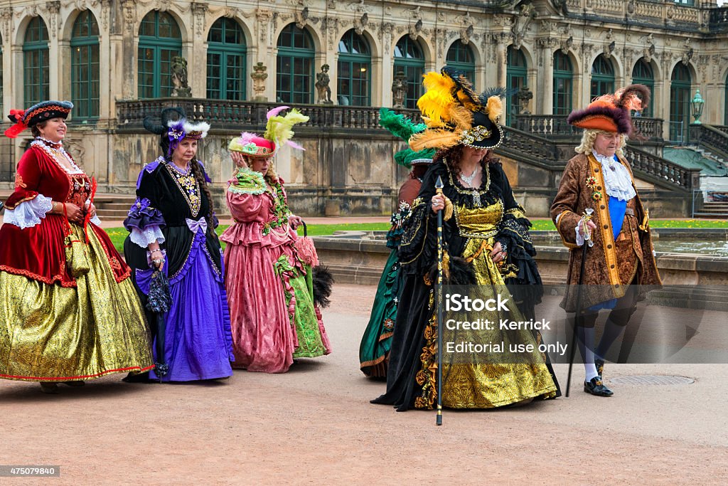 noble ladys in baroque clothes walking trough Dresden Dresden, Germany - April 21, 2014: noble ladys in baroque clothes walking trough Dresden. On some days in the year some actors dress themselvs in historic noble clothings and walking trough the old town of Dresden - Saxony Germany. They show the tourists the old time and posing for photos. Here the ladys walking trough the old town.  2015 Stock Photo
