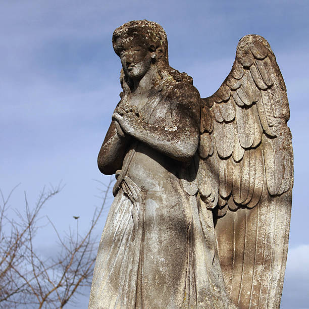 istock Figure of a praying angel on a blue sky 475082866