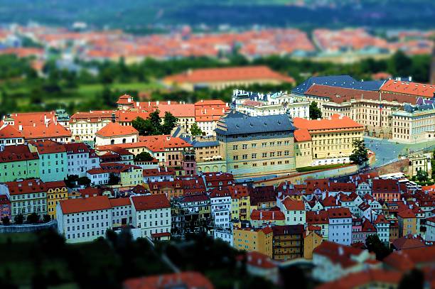 Red Prague roofs and square with lot of small people - view from the City Hall, travel european sunny background with tilt-shift blurred effect