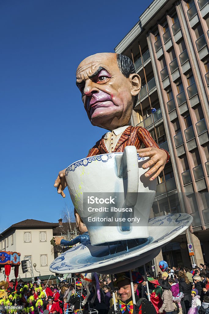 Italian Carnival celebration parade in small town Borgosesia, Italy - February 23, 2014: A man holding a puppet representing the former leader of the democratic party Pier Luigi Bersani during a carnival celebration parade in Borgosesia, Italy. Adult Stock Photo