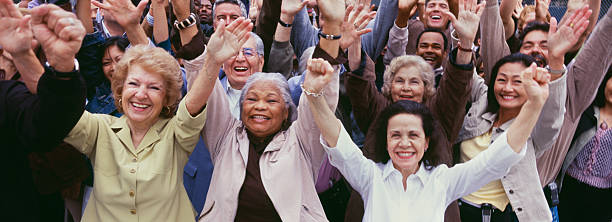 Large group of multi-ethnic people cheering with arms raised Large group of multi-ethnic people cheering with arms raised cheering group of people success looking at camera stock pictures, royalty-free photos & images