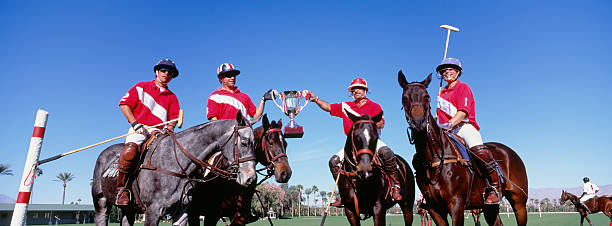 istock Multiethnic polo team celebrating with trophy on field 475085143