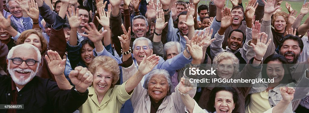 Grande gruppo di multi-etnico persone tifo con le braccia sollevate - Foto stock royalty-free di Terza età