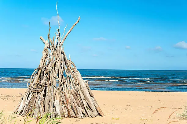 Photo of Wigwam Made from wooden branches on the baltic sea beach