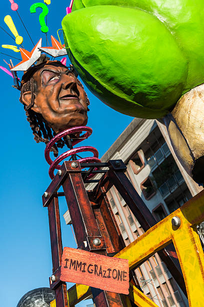 Borgosesia, Italy - February 23, 2014: A puppet representing the immigration issue hit by an Italian boxing glove during a carnival celebration parade in Borgosesia, Italy.