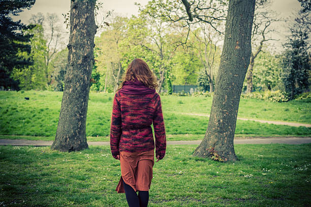 istock Young woman walking in the park 475089192