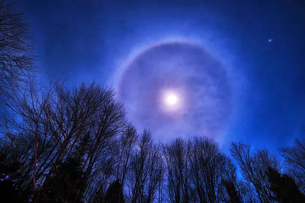 Photo of the night sky featuring a Moon Corona or Halo on a winter's night.