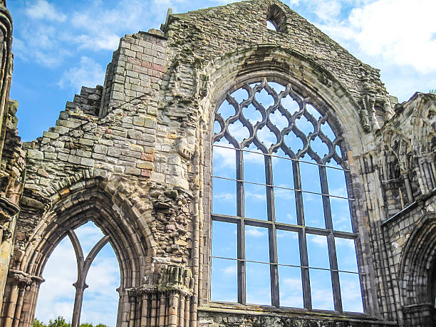 Holyrood Abbey is a ruined abbey of the Canons Regular in Edinburgh, Scotland. The abbey was founded in 1128 by King David I. During the 15th century, the abbey guesthouse was developed into a royal residence, and after the Scottish Reformation the Palace of Holyroodhouse was expanded further. The abbey church was used as a parish church until the 17th century, and has been ruined since the 18th century. The remaining walls of the abbey lie adjacent to the palace, at the eastern end of Edinburgh's Royal Mile. The site of the abbey is protected as a scheduled monument.