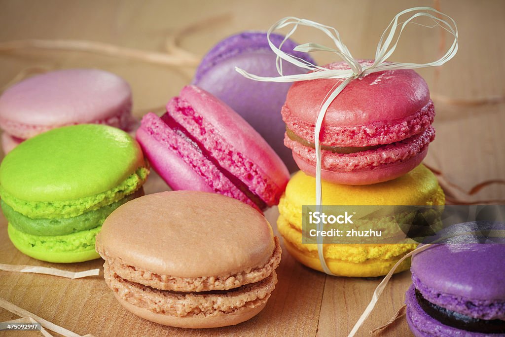 traditional french colorful macarons with a bow traditional french colorful macarons with a bow on wooden table Baked Pastry Item Stock Photo
