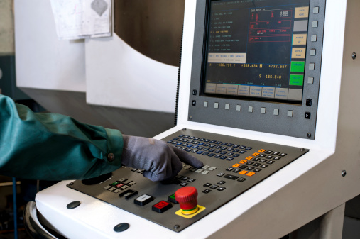 Hand on the control panel of a computer numerical control programmable machine. Milling industry