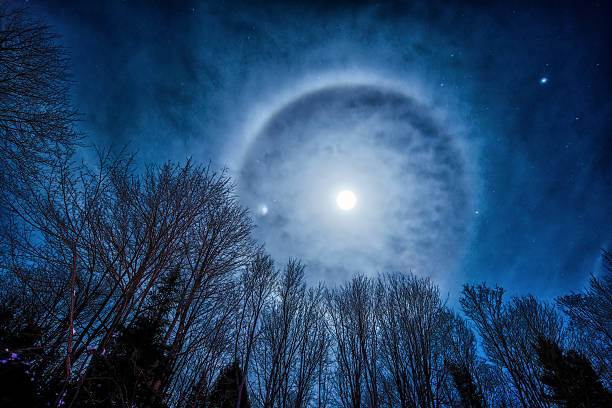 Moon Halo Photo of the night sky featuring a Moon Corona or Halo on a winter's night. halo stock pictures, royalty-free photos & images