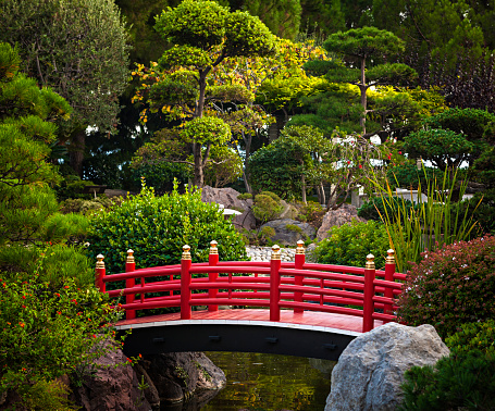 Red bridge over pond in Japanese garden. Monte Carlo, Monaco.