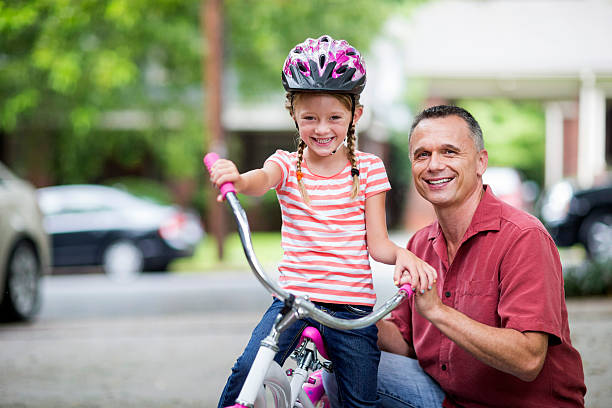 istock Father teaching daughter how to ride a bike. 475096758