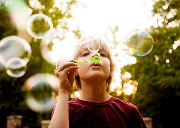 istock Little girl outside blowing bubbles with a bubble wand. 475096826