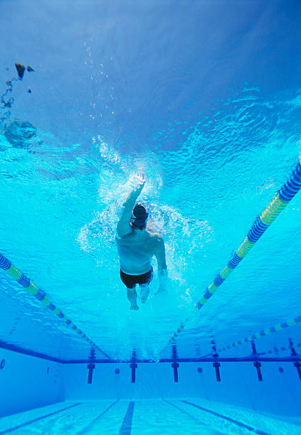 istock Underwater shot young male athlete doing backstroke in swimming pool 475098185