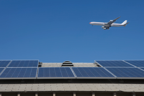 Aeroplane flying over rooftop with solar panels in Los Angeles; California