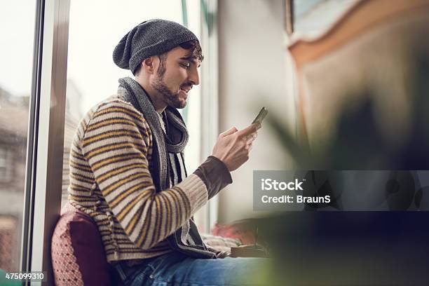 Below View Of Smiling Man Text Messaging On Mobile Phone Stock Photo - Download Image Now