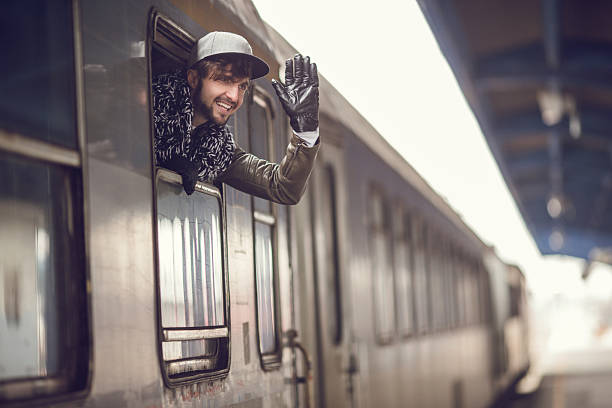 istock Young happy man waving to someone from the train. 475099360